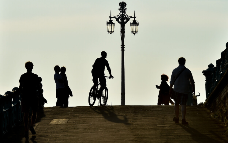 People enjoying Brighton promenade at sunset